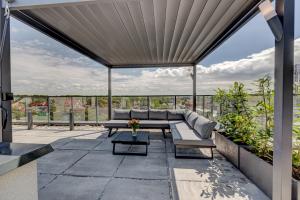 eine Terrasse mit einem Sofa und einem Tisch in der Unterkunft APARTAMENTY Z TARASEM NA DACHU NA WYDMACH W MIĘDZYWODZIU in Międzywodzie