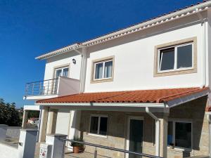 une maison blanche avec un toit rouge dans l'établissement Chez Ilda - Casa da Ilda Alojamento Local, 