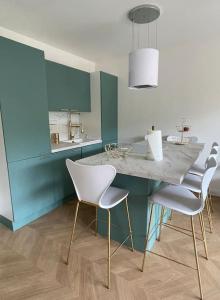 a kitchen with a table and chairs in a room at Appartement Victor Hugo 6 couchages in Biarritz
