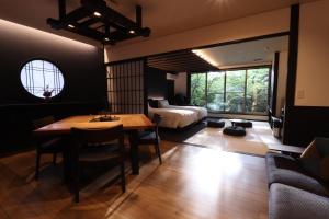 a living room with a table and a bed at Yumoto Ueyama Ryokan in Himeji