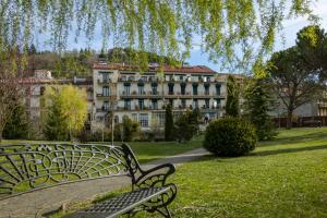 un banc devant un grand bâtiment dans l'établissement Hotel de Camprodón, à Camprodon