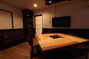 a living room with a wooden table and a couch at Yumoto Ueyama Ryokan in Himeji