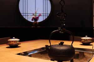 a black tea kettle on a table with a mirror at Yumoto Ueyama Ryokan in Himeji