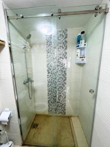 La salle de bains est pourvue d'une cabine de douche en verre. dans l'établissement SAM HOUSE 2 min à l'aéroport, à Tanger