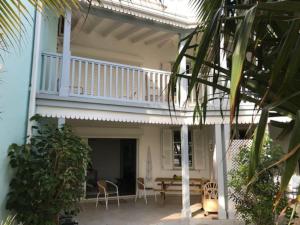 a house with a balcony and a table and chairs at Welcome to Baie Orientale plage - 4 personnes - max 6 personnes in Orient Bay