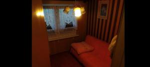 salon z czerwoną kanapą i oknem w obiekcie Stefin kutak w mieście Bosanski Novi