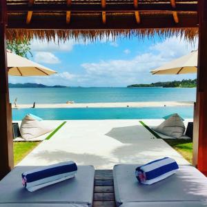 a view of the beach from a table with umbrellas at The Suites Lombok in Sekotong