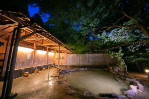 a pool of water in a backyard at night at Yumoto Ueyama Ryokan in Himeji