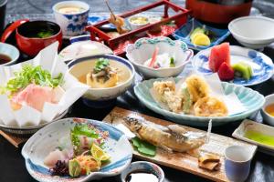 a table topped with plates of food and bowls of food at Yumoto Ueyama Ryokan in Himeji