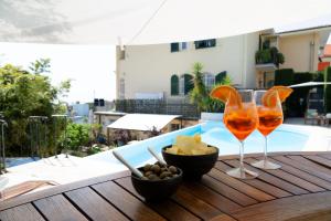 een tafel met twee wijnglazen en een kom eten bij Casa Milena elegante dimora con piscina privata in Albissola Marina