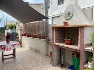 a small patio with a table and a building with plants at Can Marcela in Deltebre