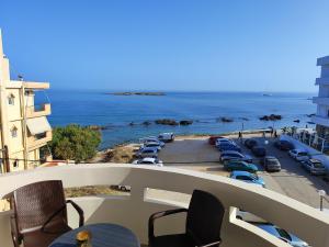 a balcony with chairs and a view of a parking lot at THALIA APARTMENTS CHANlA in Chania