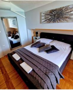 a bedroom with a large bed with a large mirror at Apartmani Marina Gradac in Gradac