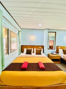 a bedroom with a large bed with two red towels at Khao Sok Nung House in Khao Sok
