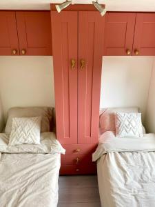two beds in a room with red cabinets at Het Hoefje in Sint Annaland