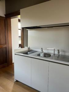a kitchen with white cabinets and a sink at Peaceful Luxury Farmhouse - Stunning Alps Views in Saluzzo