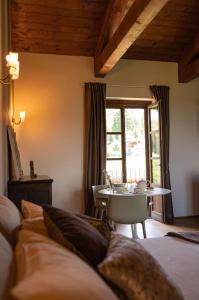 a room with a bed and a table and a window at Peaceful Luxury Farmhouse - Stunning Alps Views in Saluzzo
