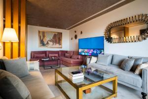 a living room with two couches and a tv at Luxury golden view apartment in les terrasses danfa ain diab in Casablanca