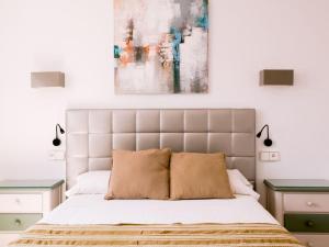 a bedroom with a bed and a painting on the wall at Villa KM2 lovely villa located just outside of Sa Carroca a 5 minute drive from Playa den Bossa in Sant Josep de Sa Talaia