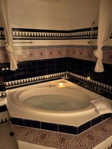 a large bath tub in a bathroom with black tiles at Hacienda Encanto del Rio in Santa Eularia des Riu