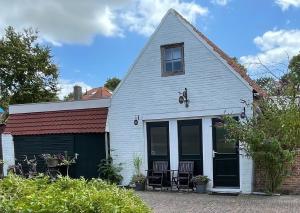 een wit huis met twee stoelen ervoor bij Silly's Inn in Middelburg