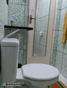 a bathroom with a toilet and a shower with a mirror at Mandala Camping - Oferecemos um espaço para sua barraca in Alto Paraíso de Goiás