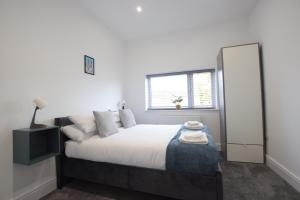 1 dormitorio con 1 cama grande y espejo en Stylish City Centre Apartments, en Lincolnshire