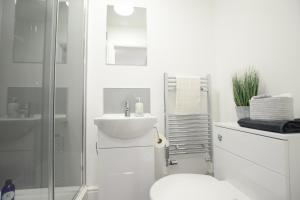 a bathroom with a toilet and a sink and a shower at Stylish City Centre Apartments in Lincolnshire +28 photos