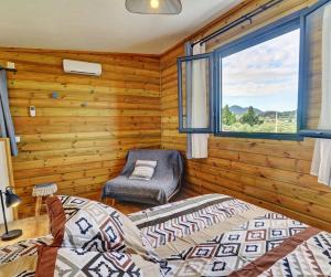 sypialnia z drewnianymi ścianami, oknem i 2 łóżkami w obiekcie L'INSTANT D'EVASION 2 Plaine des Cafres w mieście La Plaine des Cafres