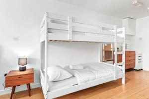 a white bunk bed in a room with a wooden table at Piccadilly, Soho 1 BR Sleep 6 VR1 in London