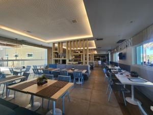 ein Restaurant mit Tischen und Stühlen und eine Cafeteria in der Unterkunft Apto Completo l Excelente Vista em Golf Ville Resort in Aquiraz