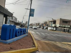 un banco azul al lado de una calle en Apart Maza en Maipú