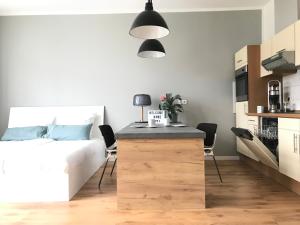 a bedroom with a bed and a kitchen with a desk at Charmantes Loft mit Balkon in Magdeburg
