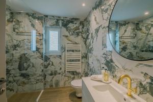bagno con servizi igienici, lavandino e specchio di HAMA Luxury Seaside Apartments a Korinthos