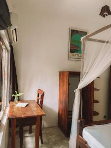 Waypoint Arugam Bay في آروغام باي: غرفة نوم مع طاولة وسرير وطاولة وكرسي