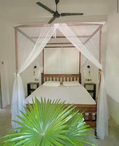 Waypoint Arugam Bay في آروغام باي: غرفة نوم مع سرير ومروحة سقف