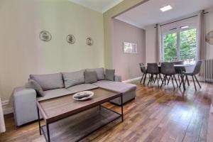 a living room with a couch and a table at Maison familiale - Gare d'Aulnay in Aulnay-sous-Bois