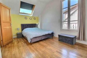 a bedroom with a bed and a large window at Maison familiale - Gare d'Aulnay in Aulnay-sous-Bois