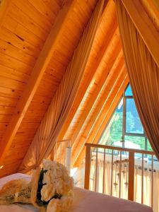 a bedroom with a wooden ceiling with a bed and a window at Usula Bungalov in Rize