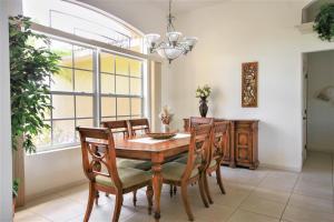 uma sala de jantar com uma mesa e cadeiras e uma janela em Villa Magnolia em Cape Coral