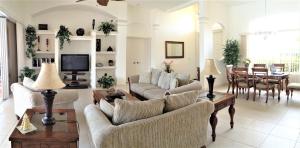uma sala de estar com 2 sofás e uma sala de jantar em Villa Magnolia em Cape Coral