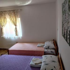 1 dormitorio con 2 camas y ventana en Vujanac vikend kuća en Raška