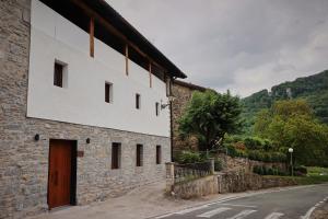 a stone building with a wooden door on a street at GOIZARTE Apartamentos turísticos rurales. 