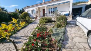 a garden of flowers in front of a house at Villa Echauguette, Chambre et toilette privee Maison partagee avec la proprietaire in Six-Fours-les-Plages