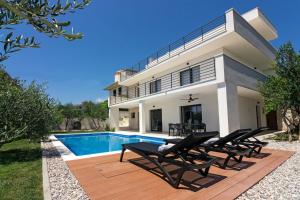 a villa with a swimming pool and a house at Family House "Villa Gyra" with Private Swimming Pool, Indoor BBQ, Gym and Gaming room! in Podstrana