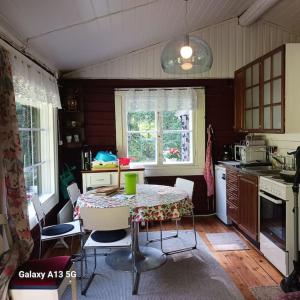 a kitchen with a table and chairs in a kitchen at Cottage / Mökki, unique summer cottage in Vihti