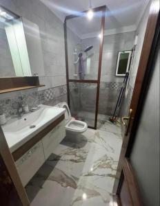 W łazience znajduje się toaleta, umywalka i prysznic. w obiekcie Nador cornich Apartement w mieście Nador