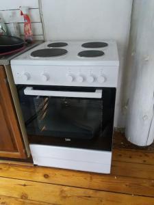 a white stove in a kitchen next to a counter at Cottage / Mökki, unique summer cottage in Vihti