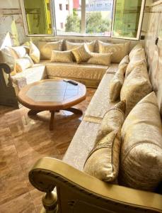 salon z dużą kanapą i stołem w obiekcie Nador cornich Apartement w mieście Nador