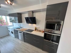 uma cozinha com um micro-ondas e um lavatório em Apartamento cerca de la playa em Denia